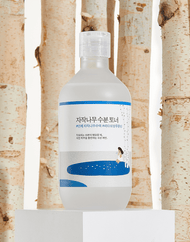 ROUND LAB Birch Juice Moisturizing Toner in front of Korean birch trees